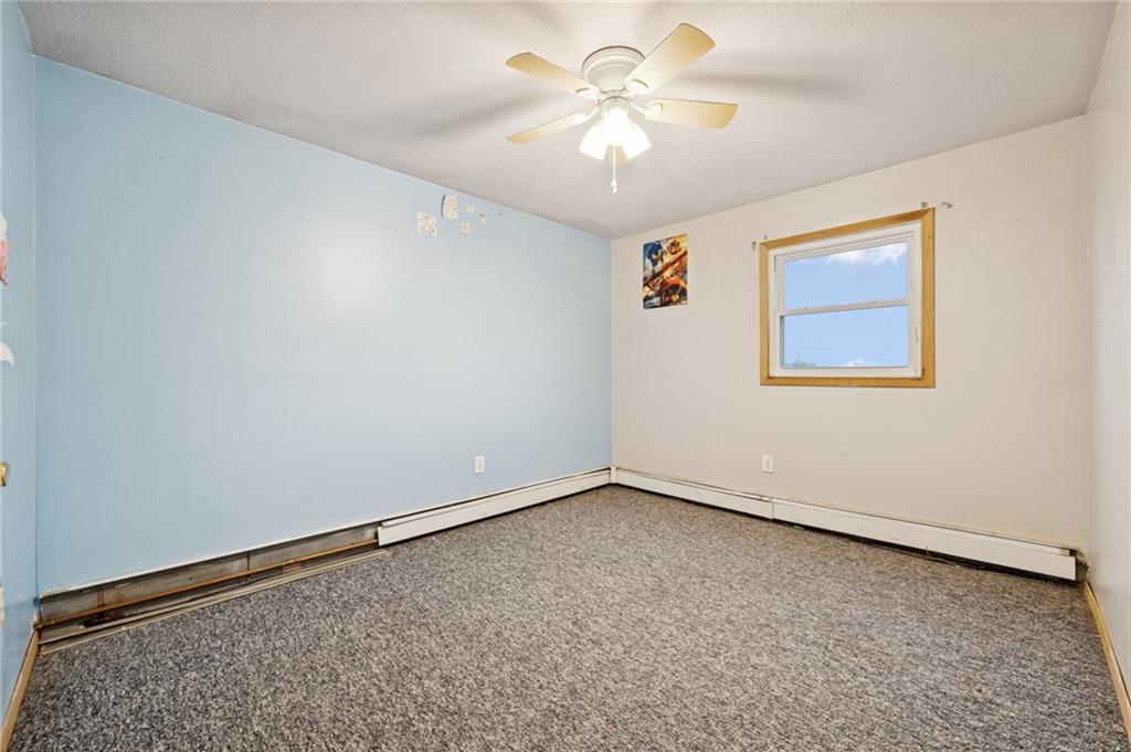 709 Westover Road Westover, PA 16692 - Photo 20 of 41 an empty room with a chandelier fan and windows