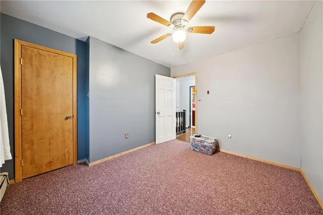 an empty room with closet and a chandelier fan