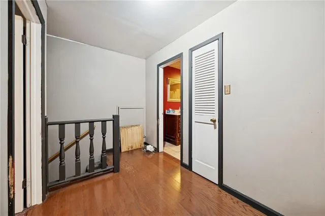 a view of a hallway with wooden floor and closet