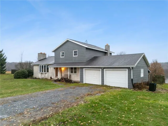 a front view of a house with a garden and yard