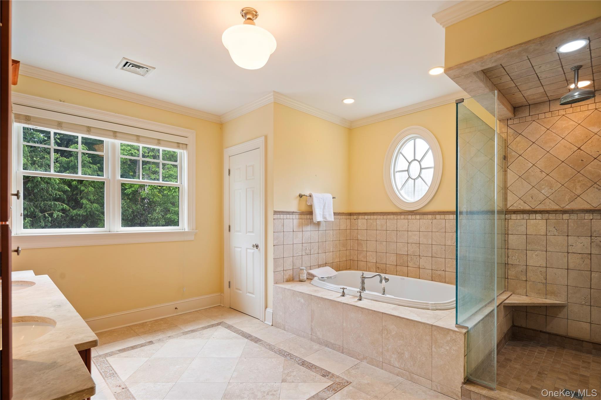 77 Byram Ridge Road Armonk, NY 10504 - Photo 32 of 48 En-suite marble spa style primary bath features jetted tub, separate shower, custom double vanity with storage towers and dual undermount sinks, frameless glass shower enclosure, separate water closet, recessed lighting, crown molding