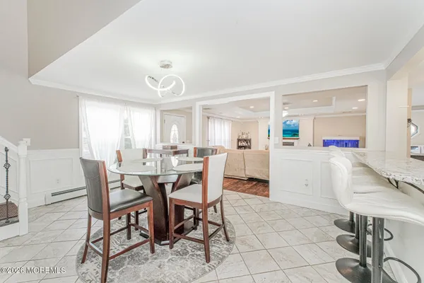 a kitchen with a dining table chairs and white cabinets