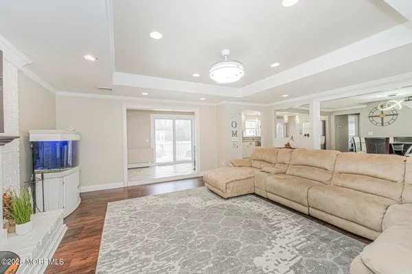 a large white bedroom with a large bed and wooden floor