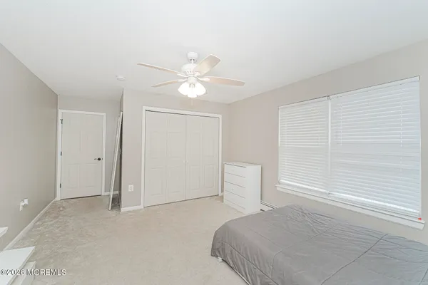 a bedroom with a white bed and white walls
