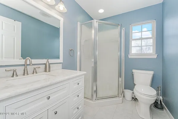 a bathroom with a granite countertop sink mirror vanity and toilet