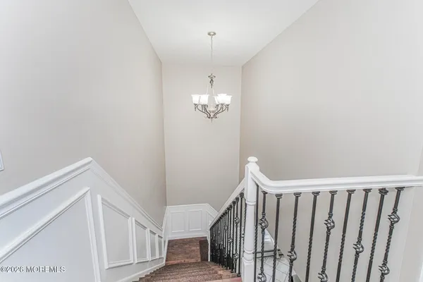 a view of a hallway with wooden floor and stairs