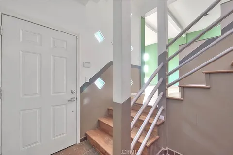 a view of an empty room with stairs and chandelier