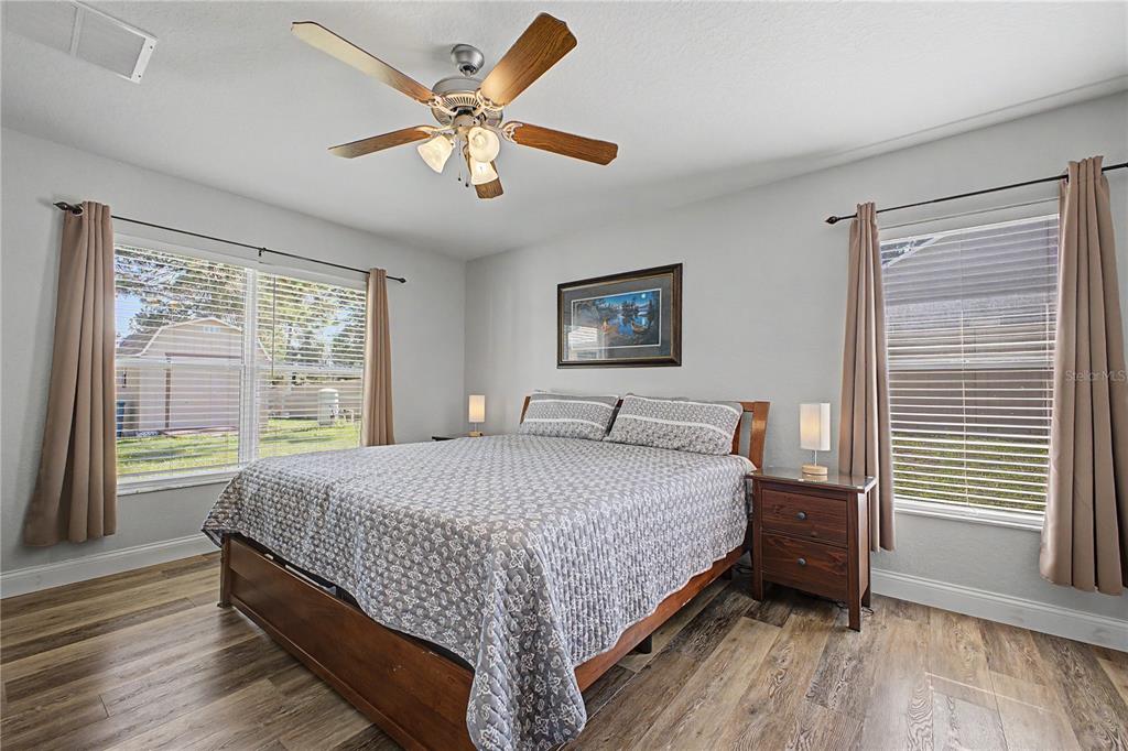 11213 Flock Avenue Weeki Wachee, FL 34613 - Photo 22 of 46 a bedroom with a large bed chandelier and a window