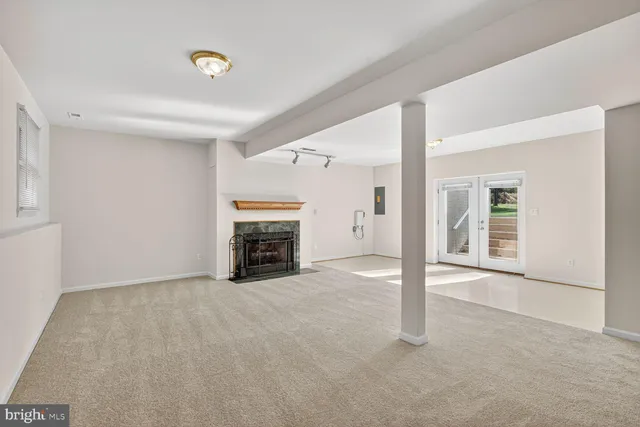 an empty room with fireplace and windows