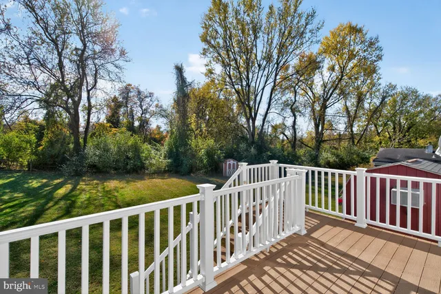 a view of a wooden deck and trees with wooden fence