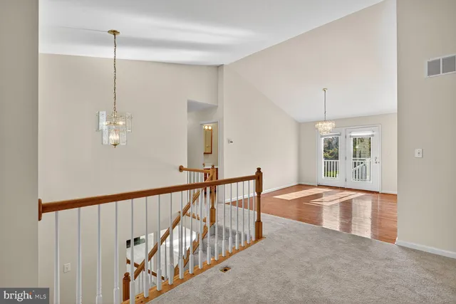 a view of an empty room with wooden floor and windows