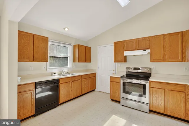 a kitchen with stainless steel appliances granite countertop a stove sink and cabinets