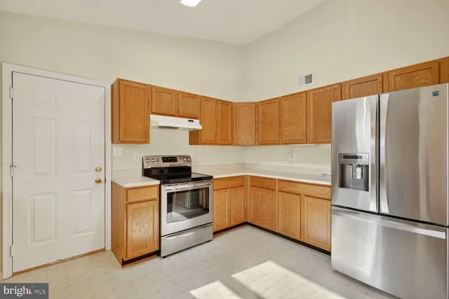 a kitchen with stainless steel appliances granite countertop a refrigerator a stove a sink and a microwave