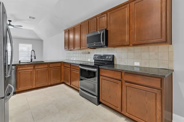 a kitchen with stainless steel appliances granite countertop a sink and cabinets