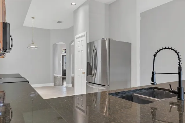 a kitchen with stainless steel appliances kitchen island a refrigerator and sink