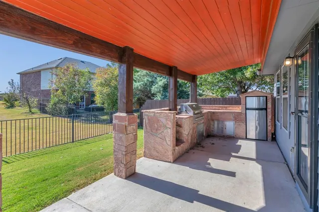 a view of a patio with table and chairs potted plants with wooden fence