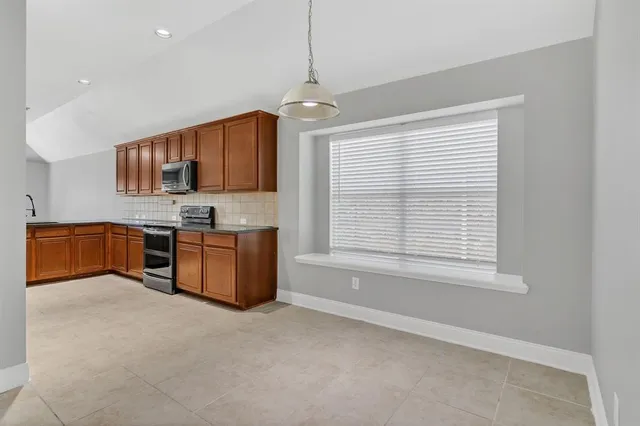 a kitchen with stainless steel appliances granite countertop a stove a sink and a refrigerator