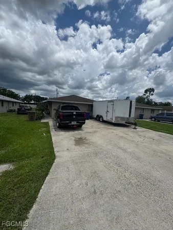 a view of a car in front of a house with a yard