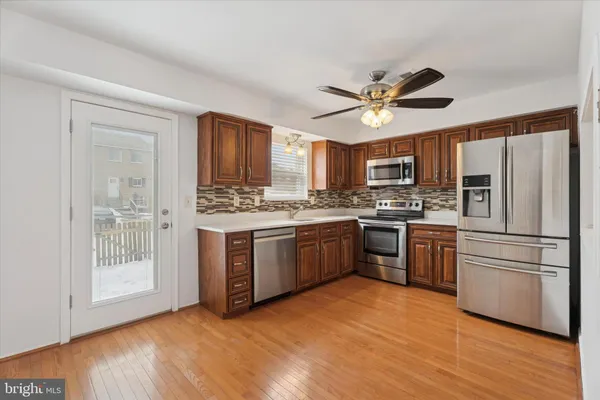 a kitchen with stainless steel appliances granite countertop a stove a sink dishwasher a refrigerator and a microwave oven with cabinets