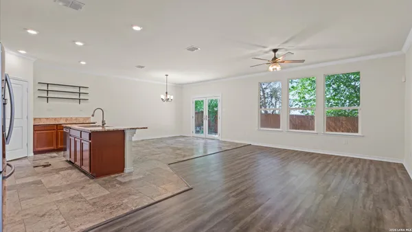an empty room with wooden floor and ceiling fan