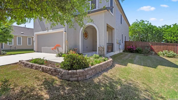 a front view of a house with a yard and potted plants