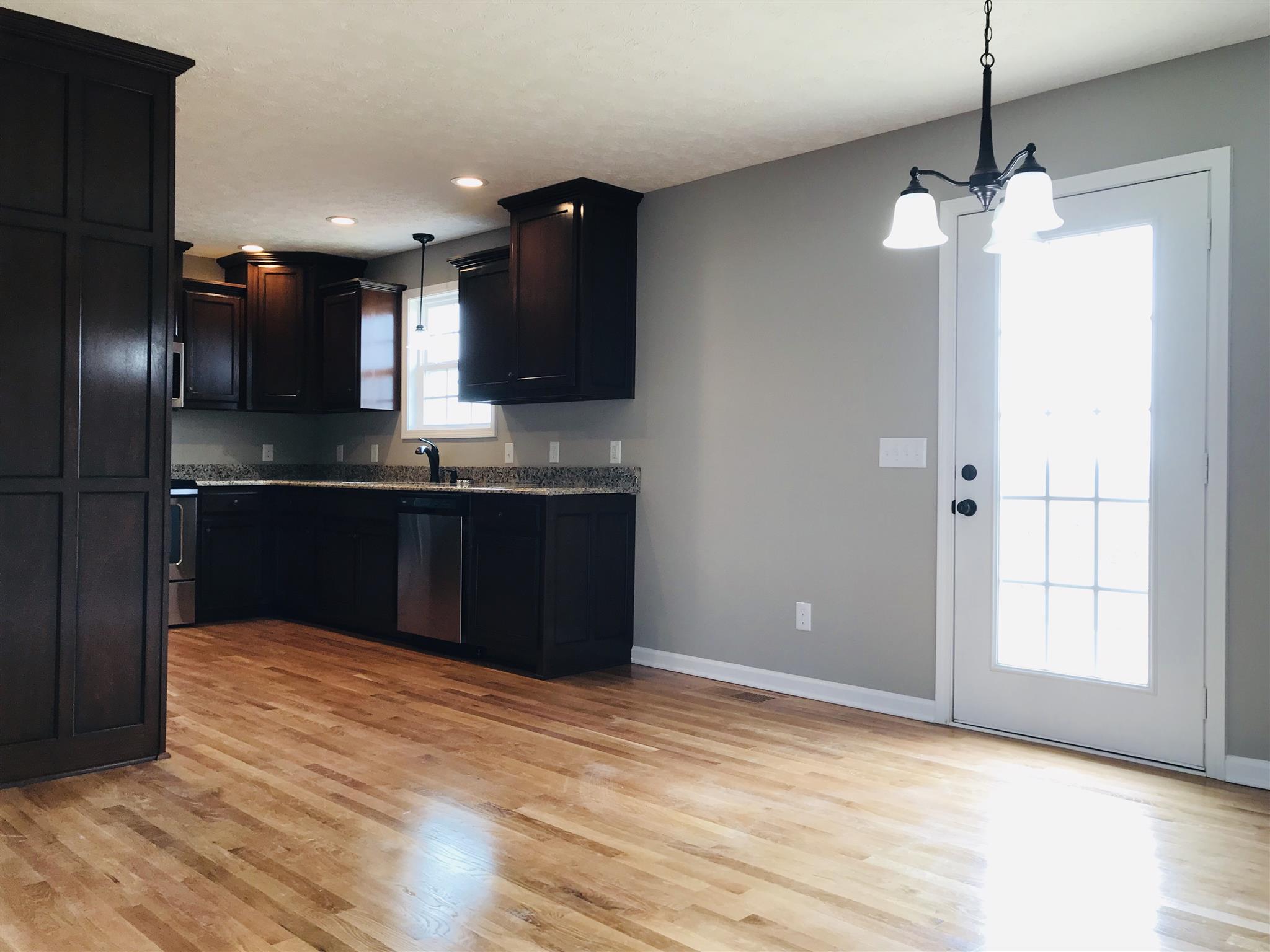 412 Fowler Ford Road Portland, TN 37148 - Photo 4 of 16 a kitchen with kitchen island stainless steel appliances a sink cabinets and wooden floor