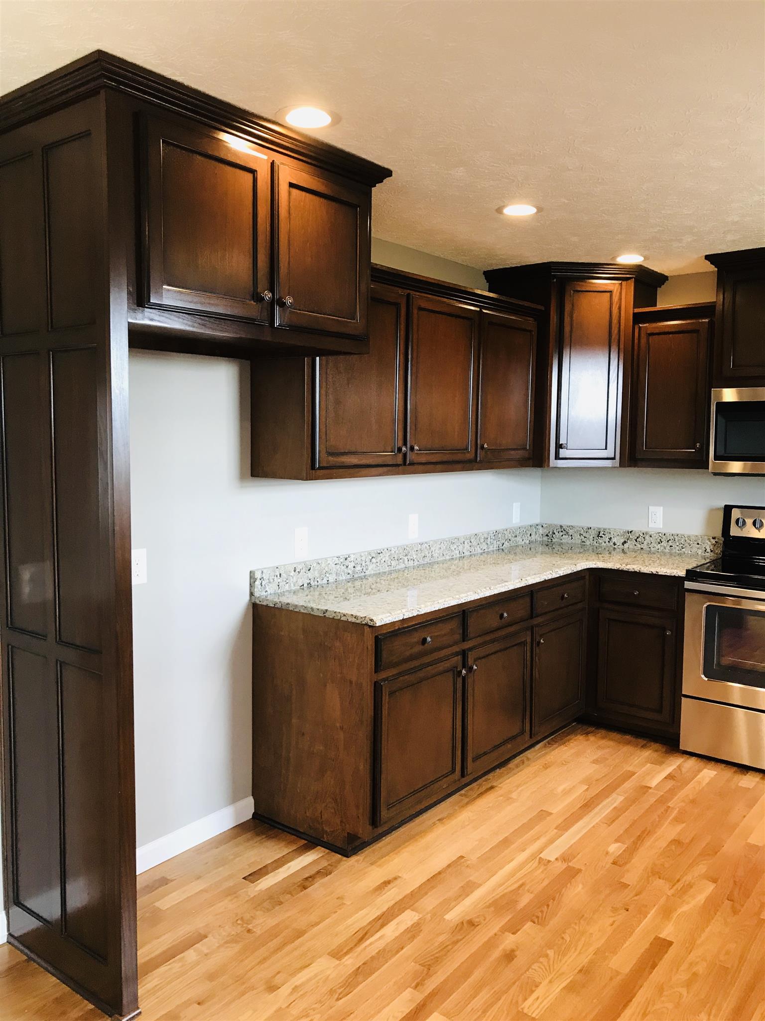 412 Fowler Ford Road Portland, TN 37148 - Photo 6 of 16 a kitchen with granite countertop a stove cabinets and microwave