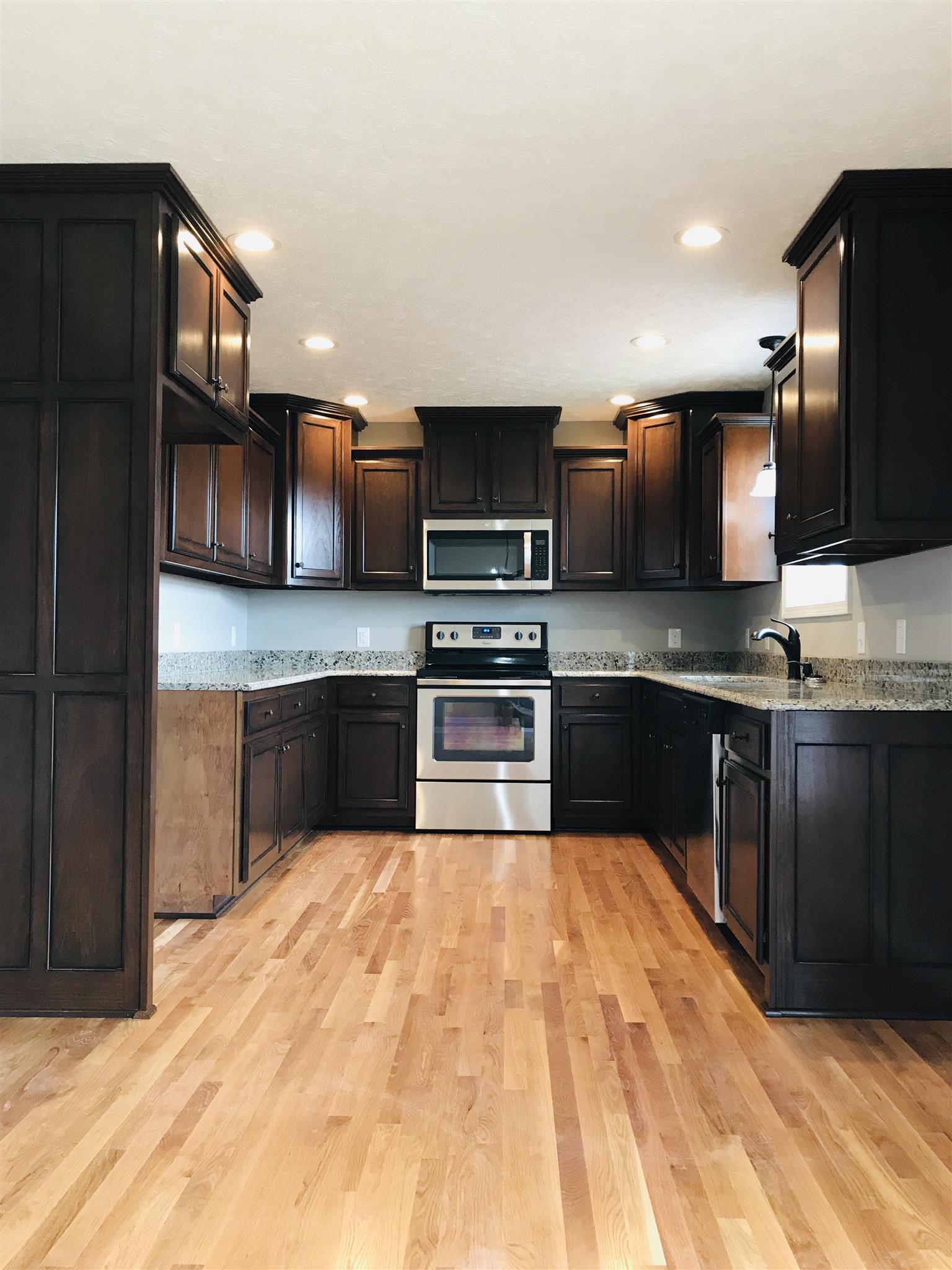 412 Fowler Ford Road Portland, TN 37148 - Photo 7 of 16 a kitchen with stainless steel appliances kitchen island granite countertop a stove a sink dishwasher a refrigerator and a microwave