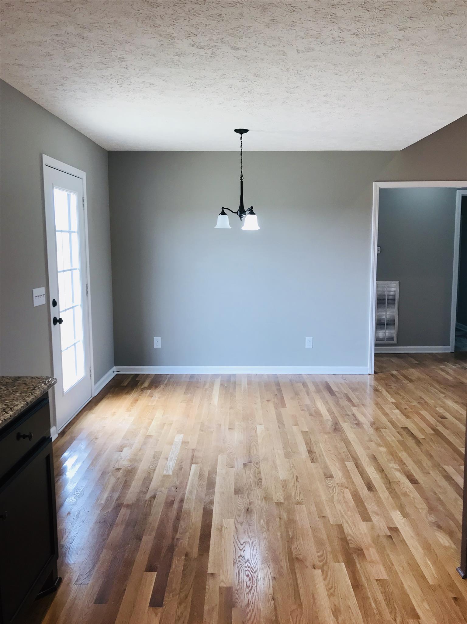 412 Fowler Ford Road Portland, TN 37148 - Photo 8 of 16 a view of empty room with wooden floor and fan