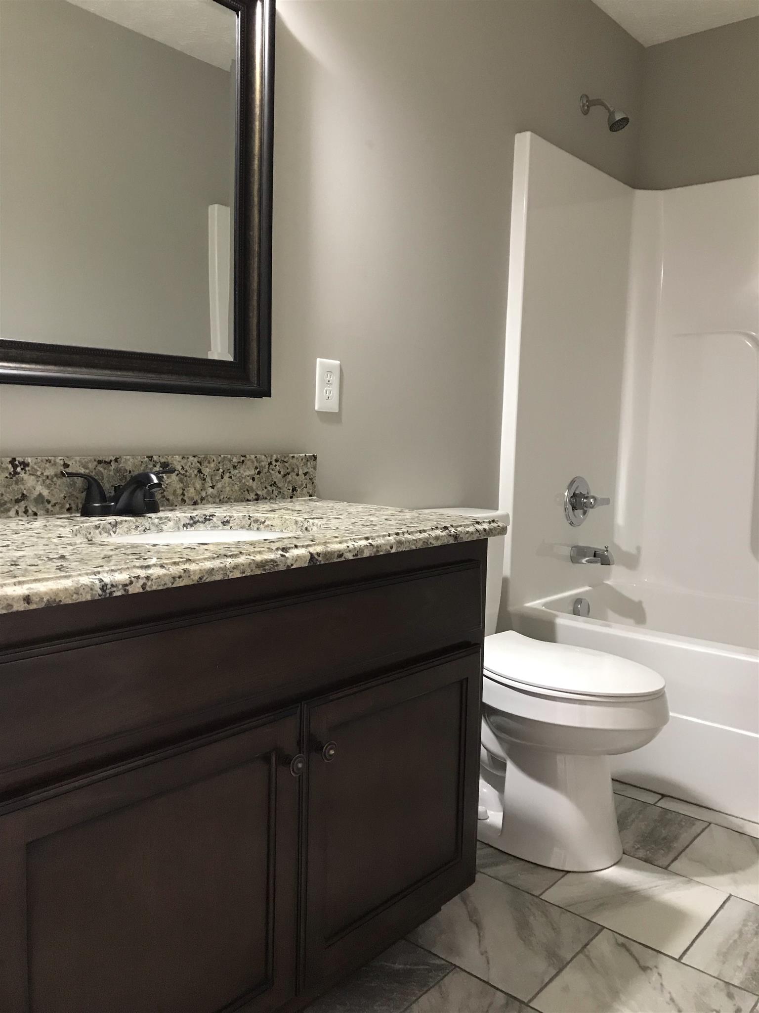 412 Fowler Ford Road Portland, TN 37148 - Photo 9 of 16 a bathroom with a granite countertop toilet sink and mirror