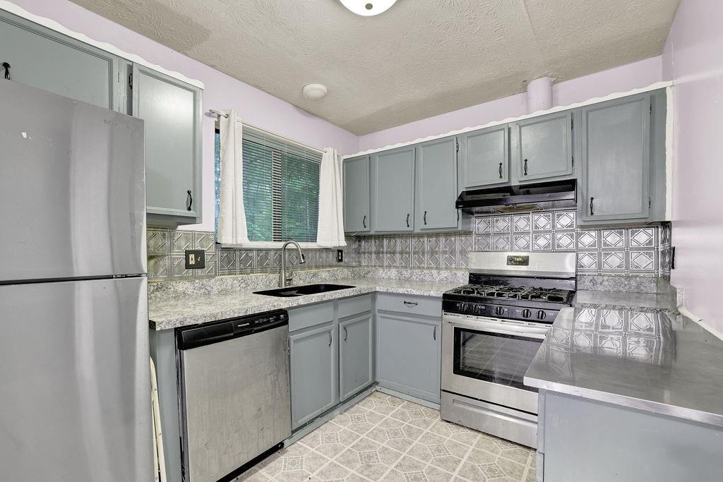 5012 Galbraith Circle Stone Mountain, GA 30088 - Photo 16 of 29 a kitchen with stainless steel appliances granite countertop a sink stove and refrigerator