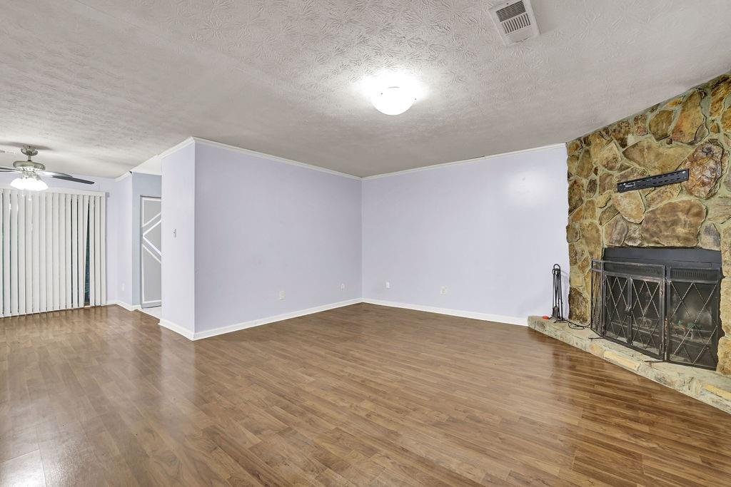 5012 Galbraith Circle Stone Mountain, GA 30088 - Photo 4 of 29 a view of an empty room with wooden floor and a fireplace