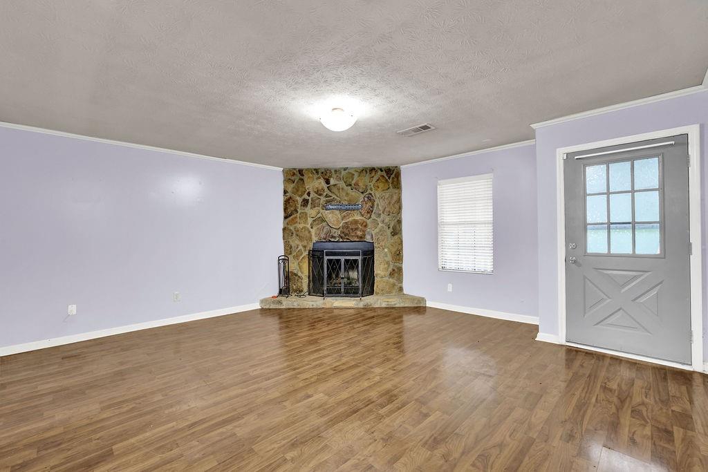 5012 Galbraith Circle Stone Mountain, GA 30088 - Photo 5 of 29 wooden floor in an empty room with a fireplace