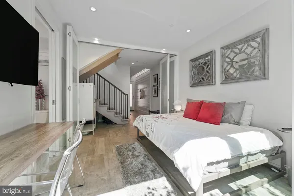 a bedroom with a large bed and painting on the wall