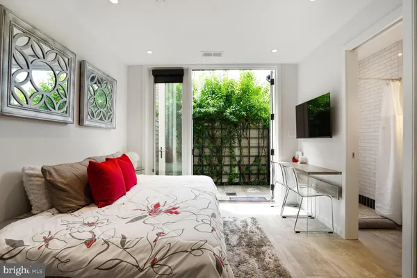 a bedroom with a large bed and a flat tv screen on the dresser