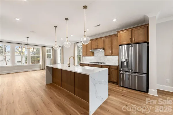 a large kitchen with kitchen island a large island a sink stainless steel appliances and cabinets