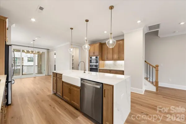 a large kitchen with kitchen island a stove a sink a oven and a refrigerator