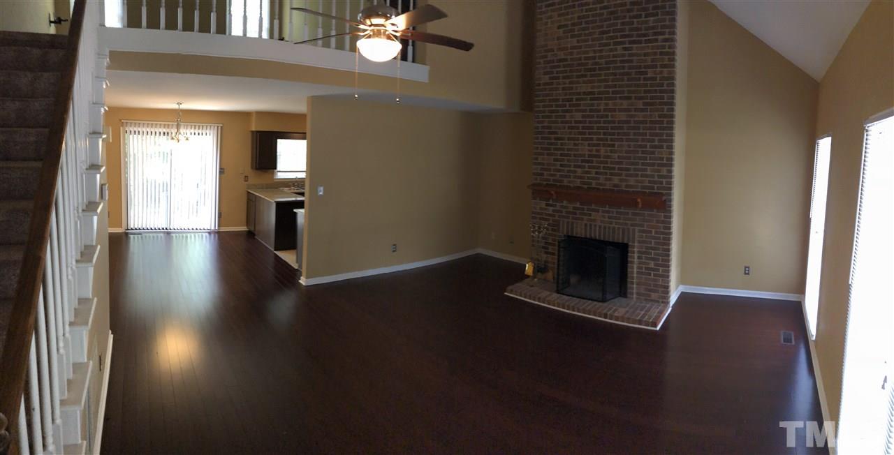 11812 North Exeter Way Raleigh, NC 27613 - Photo 5 of 25 a view of a livingroom with wooden floor a fireplace and window