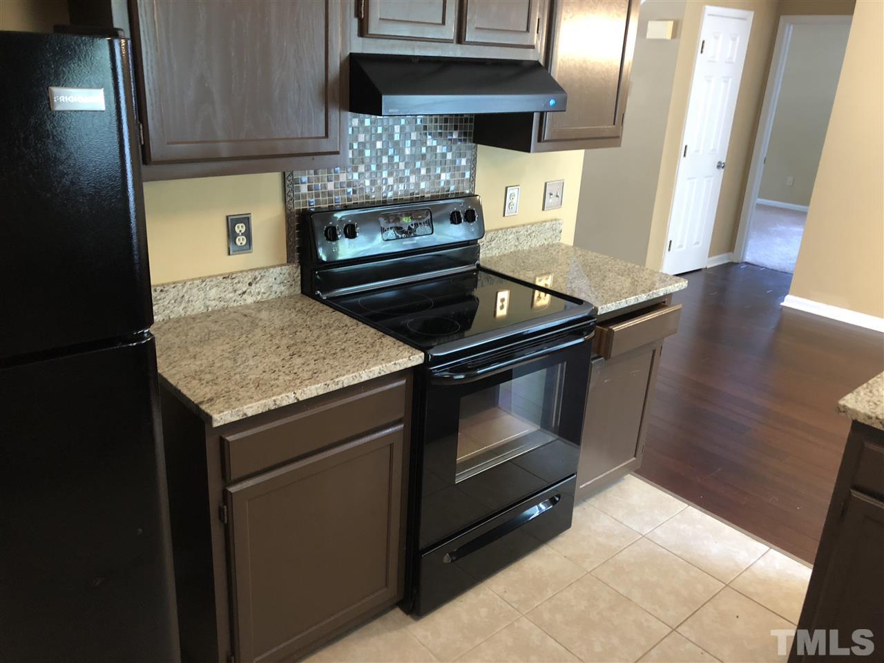 11812 North Exeter Way Raleigh, NC 27613 - Photo 9 of 25 a kitchen with a stove and a refrigerator