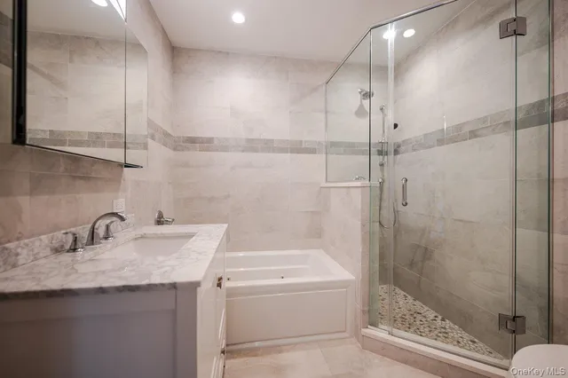 a bathroom with a granite countertop sink a toilet and shower