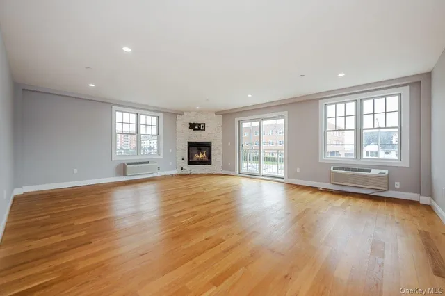 a view of empty room with wooden floor and fireplace