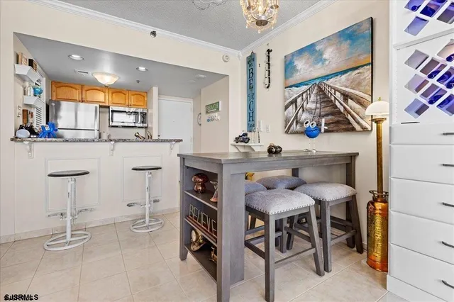 a kitchen with stainless steel appliances kitchen island granite countertop dining table chairs cabinets and a counter top space