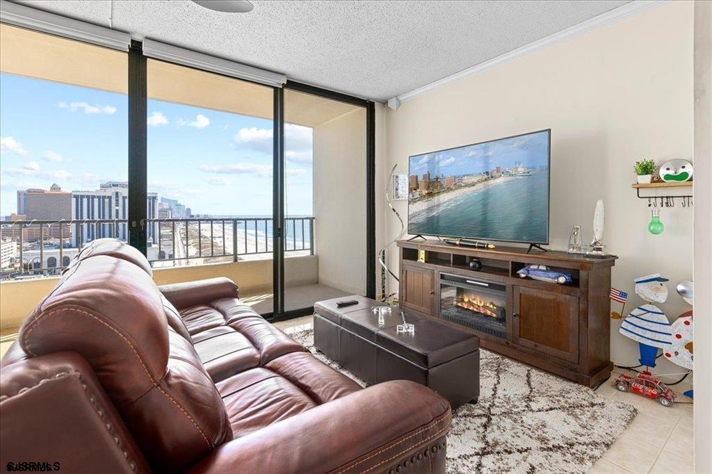 3851 Boardwalk, Unit 2005 Atlantic City, NJ 08401 - Photo 13 of 28 a living room with furniture a flat screen tv and a floor to ceiling window