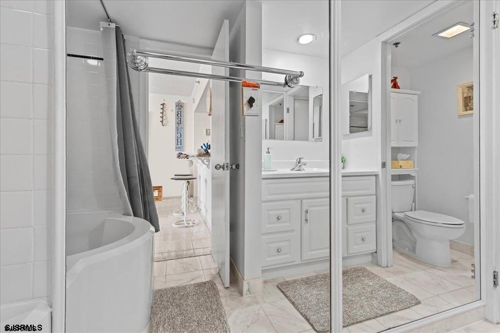 3851 Boardwalk, Unit 2005 Atlantic City, NJ 08401 - Photo 18 of 28 a bathroom with a granite countertop sink toilet and shower