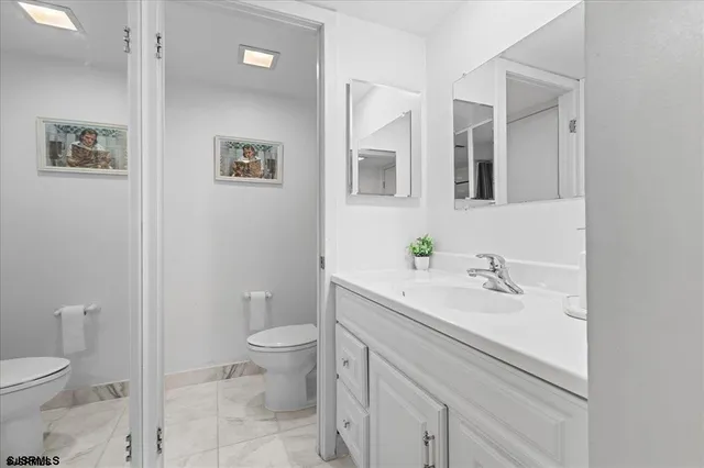 a bathroom with a sink a toilet and a mirror