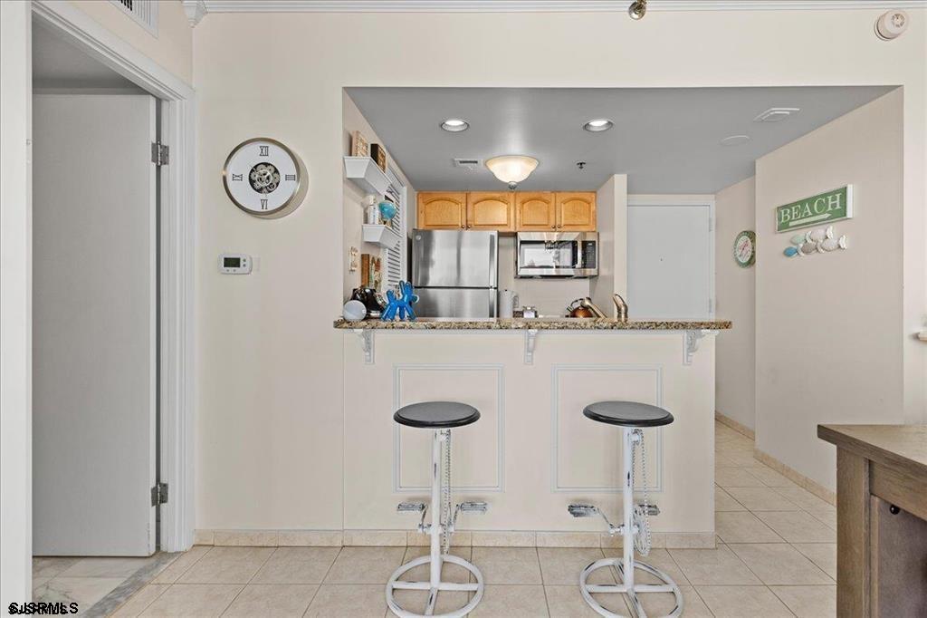 3851 Boardwalk, Unit 2005 Atlantic City, NJ 08401 - Photo 6 of 28 a kitchen with a counter space and chairs in it