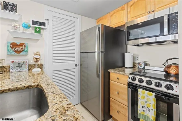 a kitchen with stainless steel appliances granite countertop a refrigerator and a stove