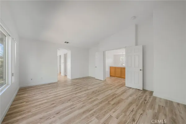 a view of empty room with wooden floor and window