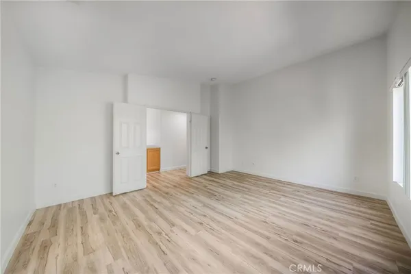 a view of empty room with wooden floor