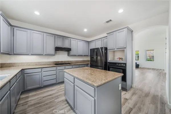 a kitchen with kitchen island a counter top space stainless steel appliances and cabinets